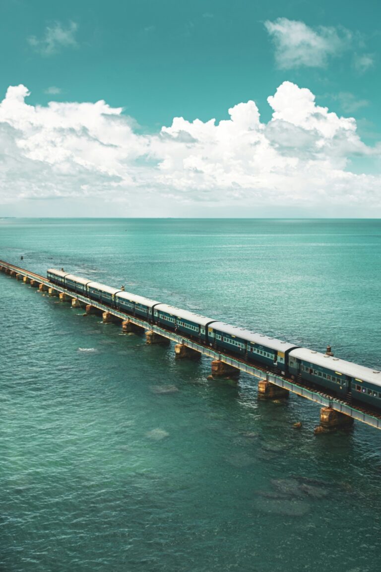 A train crossing the iconic Pamban Bridge, with the railway tracks aligned against the backdrop of the sea, showcasing the bridge's unique cantilever design and engineering marvel.