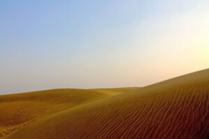 Expansive view of Sam Sand Dunes, featuring golden sand hills under a clear blue sky, highlighting the beauty of the Thar Desert.