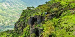 Historic Sinhagad Fort perched on a hilltop near Pune, India, surrounded by rugged terrain and lush greenery, known for its strategic importance and connection to Maratha warrior Tanaji Malusare.