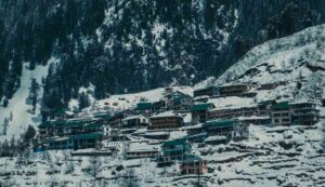 Stunning panorama of Solang Valley in Manali, featuring lush green meadows, snow-capped mountains, and adventure activities like paragliding and skiing.